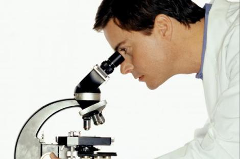 man looking at a microscope
